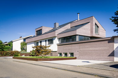 Großes, Dreistöckiges Modernes Haus mit brauner Fassadenfarbe, Satteldach und Schindeldach in Stuttgart