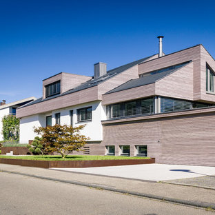 Großes, Dreistöckiges, Braunes Modernes Einfamilienhaus mit Holzfassade, Satteldach und Schindeldach in Stuttgart