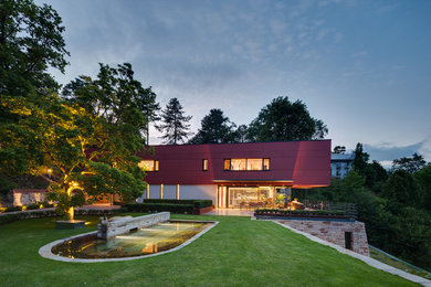 Foto de fachada roja contemporánea grande de dos plantas con tejado plano y revestimientos combinados
