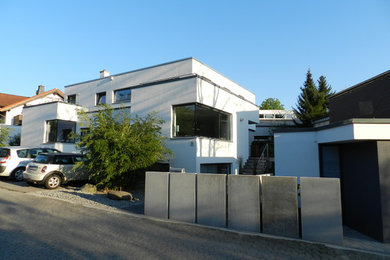 Mittelgroße, Zweistöckige Moderne Doppelhaushälfte mit Putzfassade, weißer Fassadenfarbe und Flachdach in Frankfurt am Main