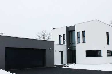 Zweistöckiges, Mittelgroßes Modernes Haus mit weißer Fassadenfarbe, Flachdach und Putzfassade in Sonstige