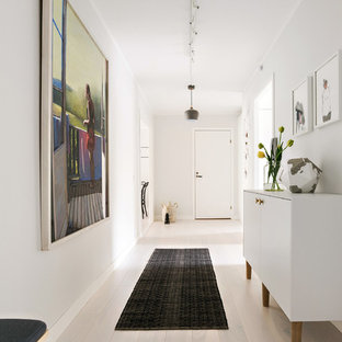 Idéer för att renovera en funkis hall, med vita väggar, ljust trägolv och beiget golv