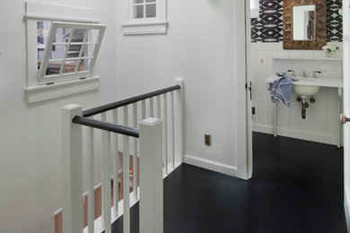 Example of a small transitional dark wood floor and black floor hallway design in Los Angeles with white walls
