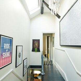 Réalisation d'un couloir bohème avec un mur blanc et un sol noir.