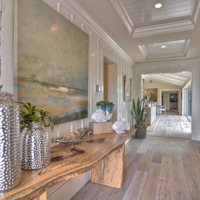 Example of a beach style medium tone wood floor hallway design in Los Angeles with white walls