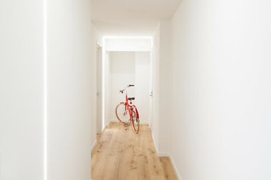 Example of a minimalist light wood floor hallway design in San Francisco with white walls