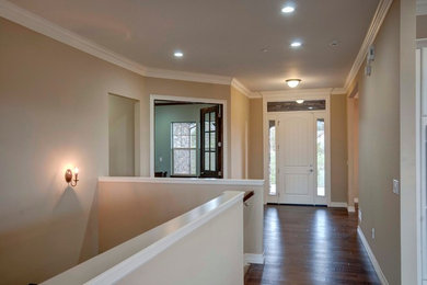Inspiration for a contemporary dark wood floor hallway remodel in Denver with beige walls