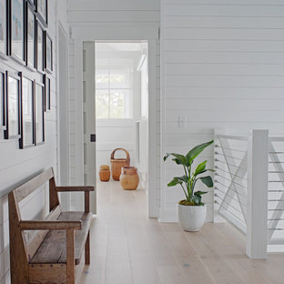 Hallway - small coastal light wood floor and brown floor hallway idea with white walls