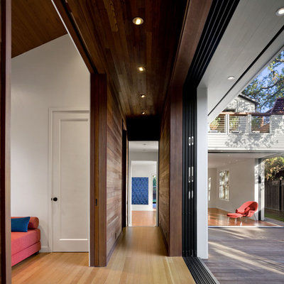 Hallway - contemporary medium tone wood floor hallway idea in San Francisco with white walls