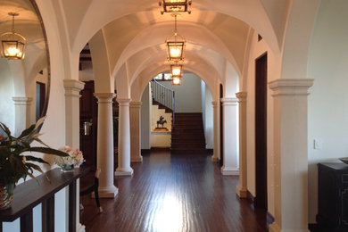 Modelo de recibidores y pasillos mediterráneos grandes con paredes beige y suelo de madera oscura