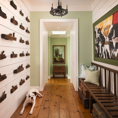 Cottage medium tone wood floor hallway photo in Dallas with green walls