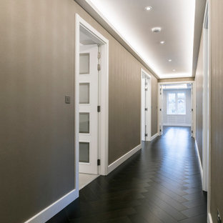 Réalisation d'un grand couloir design avec un mur beige, un sol en bois foncé, un sol marron, un plafond à caissons et du papier peint.