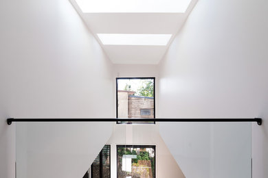 Idée de décoration pour un couloir minimaliste de taille moyenne avec un mur blanc.