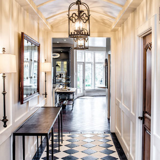 Exemple d'un couloir chic avec un mur blanc et un sol noir.
