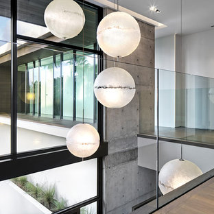 Exemple d'un très grand couloir moderne avec un mur blanc, un sol en bambou et un sol beige.