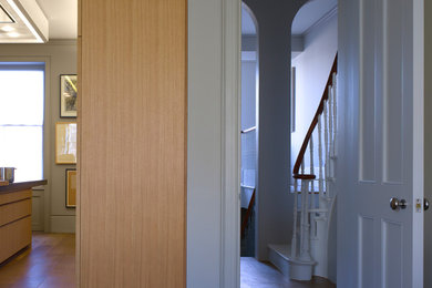 Imagen de recibidores y pasillos contemporáneos con paredes grises y suelo de madera en tonos medios