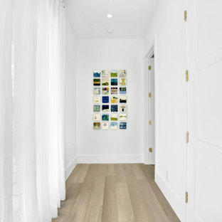 Idées déco pour un très grand couloir contemporain avec un mur blanc, un sol en bois clair, un sol beige et un plafond à caissons.