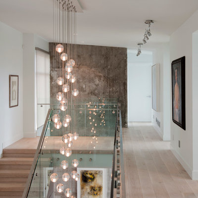 Example of a trendy light wood floor hallway design in Vancouver with white walls