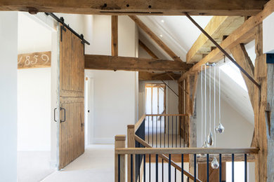 Réalisation d'un couloir chalet avec un mur blanc, moquette et un sol gris.