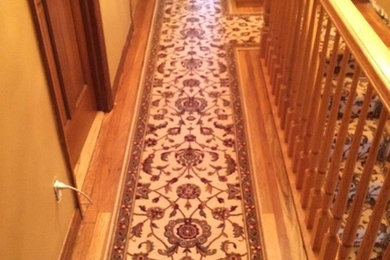 Inspiration for a small timeless light wood floor hallway remodel in New York with brown walls