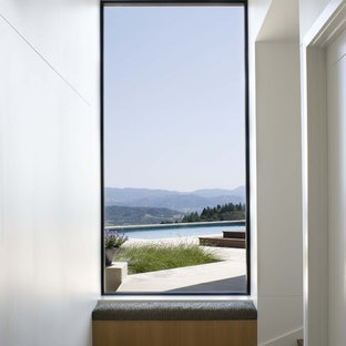 Aménagement d'un couloir moderne avec un mur blanc et un sol en bois brun.