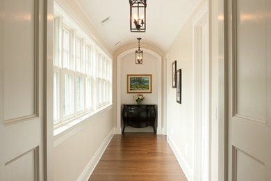 Exemple d'un couloir craftsman de taille moyenne avec un mur beige et un sol en bois brun.