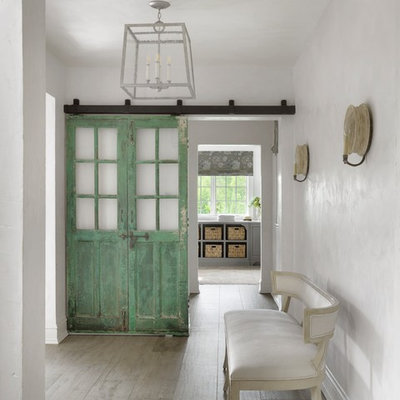 Example of a country light wood floor and gray floor hallway design in Other with white walls