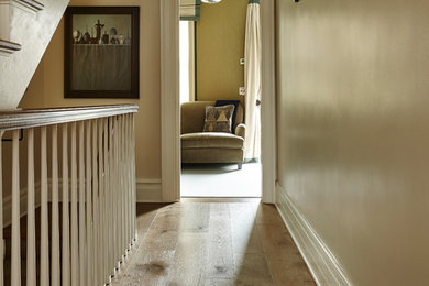 Inspiration for a mid-sized timeless medium tone wood floor and brown floor hallway remodel in New York with beige walls