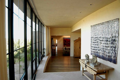 Foto de recibidores y pasillos mediterráneos grandes con paredes beige, suelo de madera en tonos medios y suelo marrón