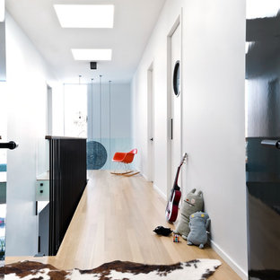 Example of a danish light wood floor hallway design in Chicago with white walls