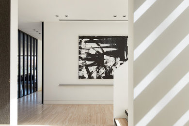 メルボルンにある広いコンテンポラリースタイルのおしゃれな廊下 (白い壁、トラバーチンの床、ベージュの床) の写真
