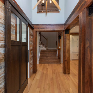 Idée de décoration pour un grand couloir champêtre en bois avec un mur bleu et un sol noir.