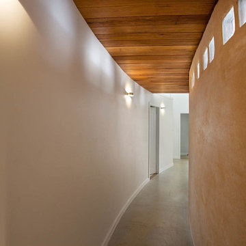 Curved cob wall, concrete floor, timber ceiling