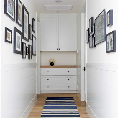 Transitional medium tone wood floor hallway photo in Los Angeles with white walls