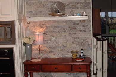На фото: коридор среднего размера в стиле неоклассика (современная классика) с серыми стенами, полом из сланца и коричневым полом