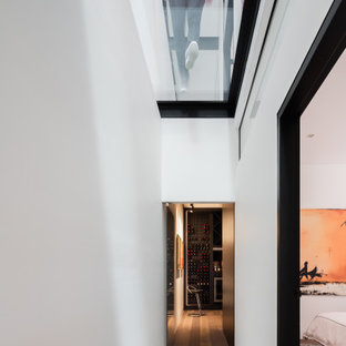 Photo of a contemporary hallway in Sydney with white walls and medium hardwood floors.