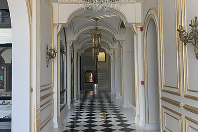 Immagine di un ingresso o corridoio chic con pareti grigie, pavimento in marmo e pavimento nero