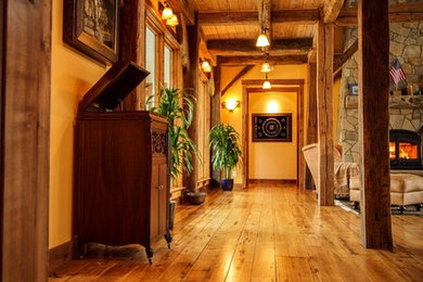 Inspiration for a large rustic medium tone wood floor and brown floor hallway remodel in Denver with beige walls