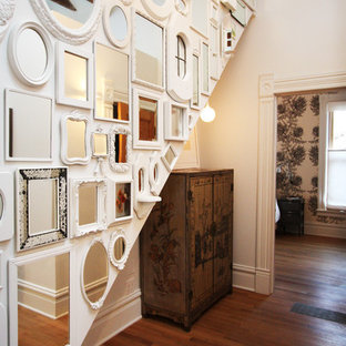 Inredning av en shabby chic-inspirerad mellanstor hall, med vita väggar och mellanmörkt trägolv