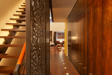 Modelo de recibidores y pasillos contemporáneos con suelo de madera oscura