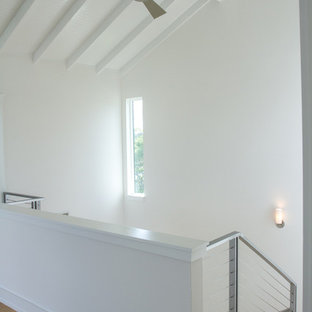 Exempel på en mellanstor modern hall, med vita väggar och bambugolv