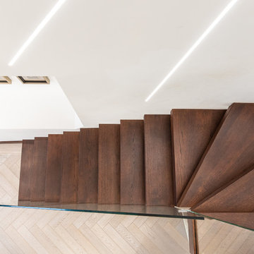 Floating stairs with frameless glass balustrade in chocolate brown colour