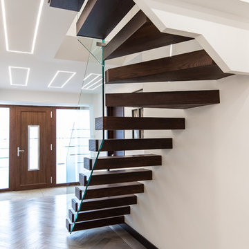 Floating stairs with frameless glass balustrade in chocolate brown colour