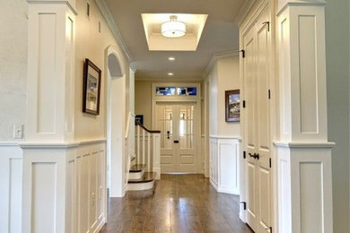 Idée de décoration pour un couloir tradition de taille moyenne avec un mur blanc, un sol en bois brun et un sol marron.