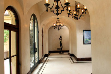 На фото: коридор в средиземноморском стиле с бежевыми стенами, мраморным полом и разноцветным полом с