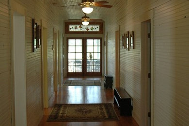 Hallway - mid-sized transitional medium tone wood floor hallway idea in Tampa with white walls