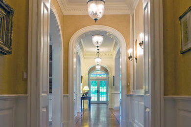 Inspiration for a large timeless light wood floor hallway remodel in New York with yellow walls