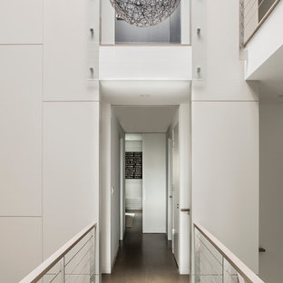 Réalisation d'un couloir minimaliste avec un mur blanc, un plafond voûté et du lambris.