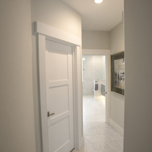 Idée de décoration pour un petit couloir design avec un mur beige, un sol en carrelage de porcelaine et un sol blanc.