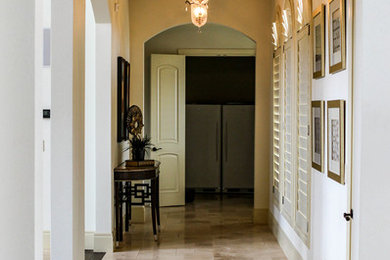 Ejemplo de recibidores y pasillos clásicos con paredes blancas y suelo de baldosas de porcelana